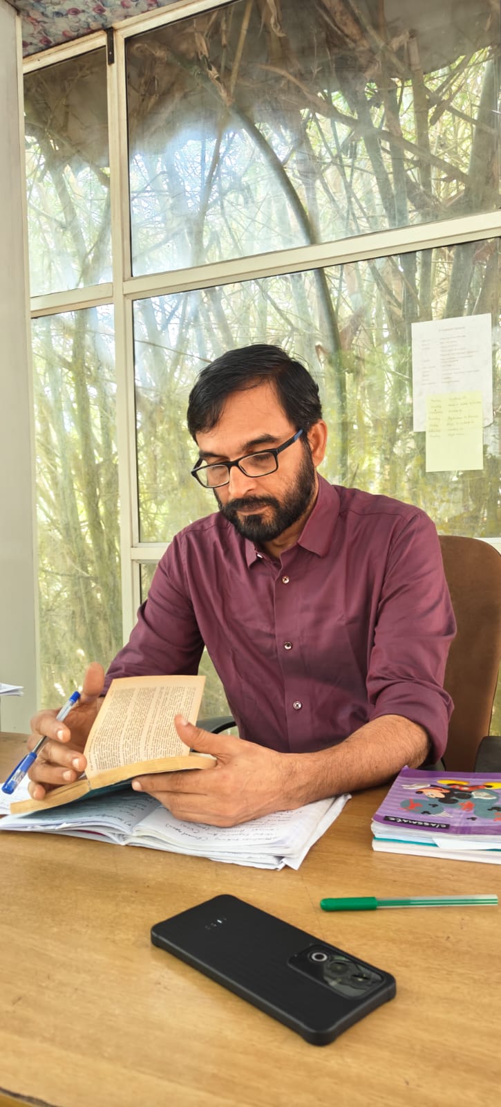 Dr. Ajith Kumar M.P reviewing notes at his desk